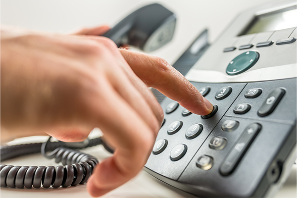 Close-up of hand dialing phone number