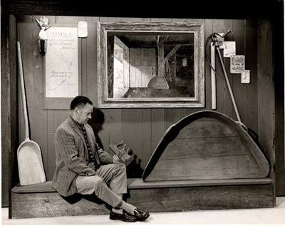 Eric Sloane sitting on a bench in a museum exhibit